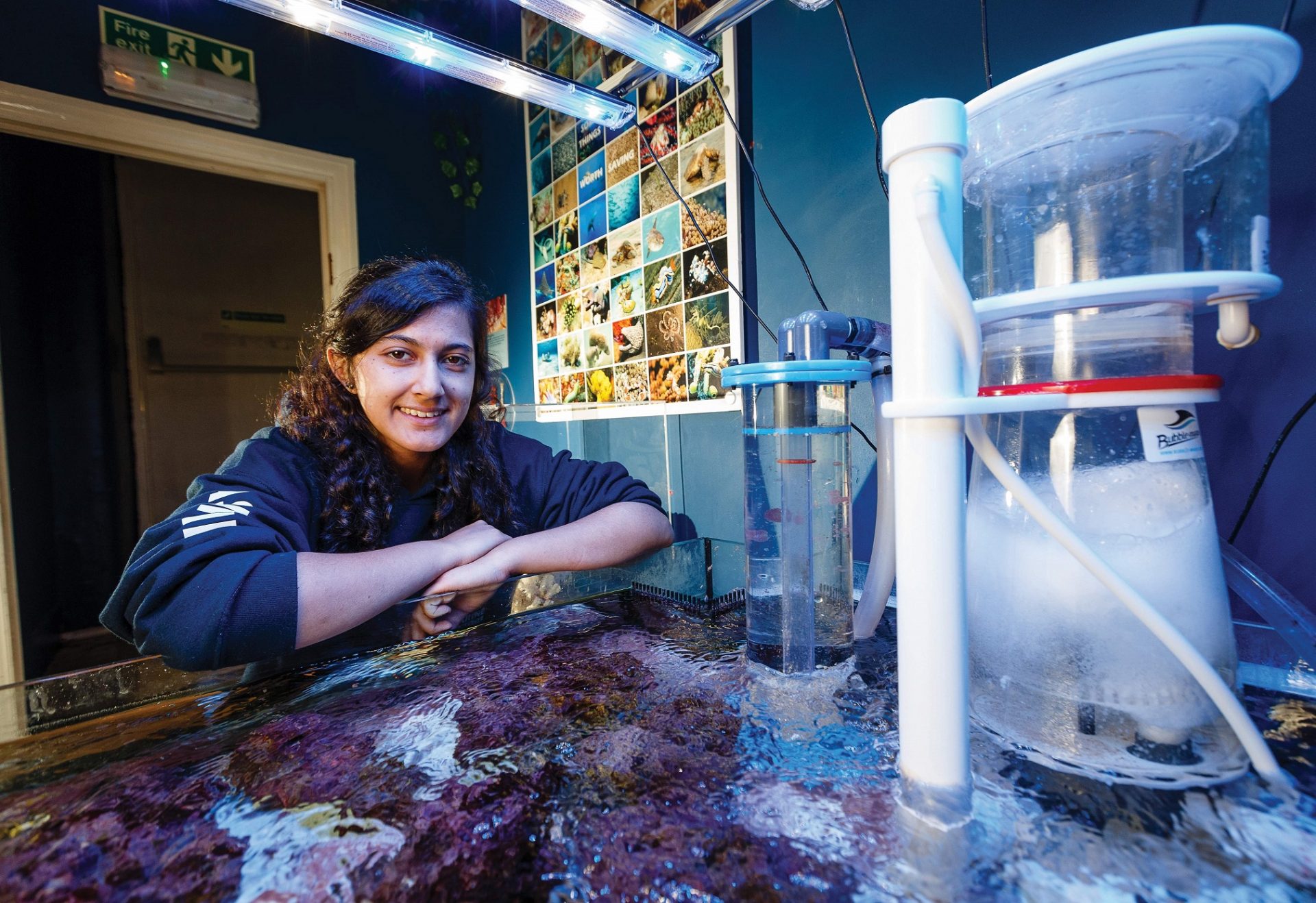 Marine biology student next to tank at Falmouth Marine School